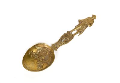 a gold spoon with a picture of a man and a woman on it