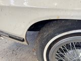 a close up of a white car with a black tire