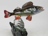 a figurine of a fish that is sitting on a rock