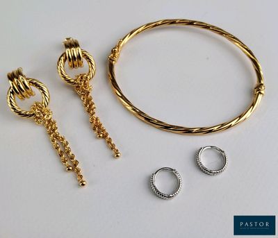 un gros plan sur un bracelet, une bague et une boucle d'oreille posés sur une table