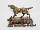 statue en bronze représentant un chien et quatre autres chiens, posée sur un socle en bois