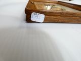 une petite horloge en bois posée sur une table, avec une étiquette de prix dessus