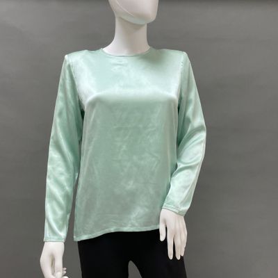 the mannequin is wearing a green top and black leggings