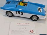 a blue and white toy car with a man in the driver seat