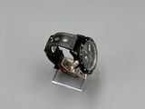 wrist watch with black leather band on clear acrylic stand