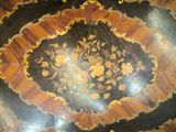 a wooden table with a black and gold design on it