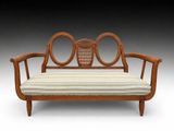 un lit de jour en bois avec un coussin rayé et deux miroirs ronds