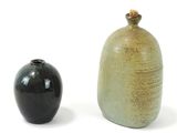 two vases sitting next to each other on a white surface
