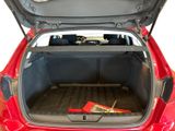 the trunk of a red car with a bunch of tools in it