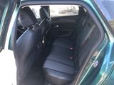 the back seat of a green car with a black seat cover