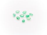 a group of green glass beads on a white surface