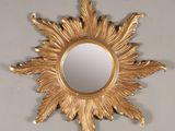 un miroir en forme d'étoile dorée accroché au mur