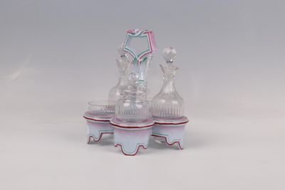 trois vases en verre posés sur un socle, sur une surface blanche
