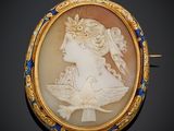 une image représentant une femme de profil, dans une broche aux couleurs or et bleu
