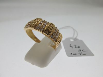 gros plan d'une bague en or avec des diamants sur une surface blanche
