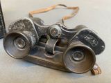 an old pair of binoculars sitting on top of a table next to a book