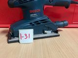un gros plan d'une ponceuse posée sur une table, avec une étiquette de prix