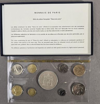 an assortment of coins in a plastic case on a table