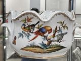 a large bowl with birds painted on it in a glass case