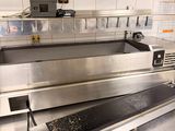 stainless steel counter top in a commercial kitchen with a stove and oven