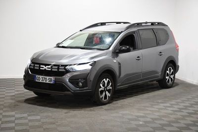 Le SUV gris est garé dans une pièce au sol carrelé en damier.