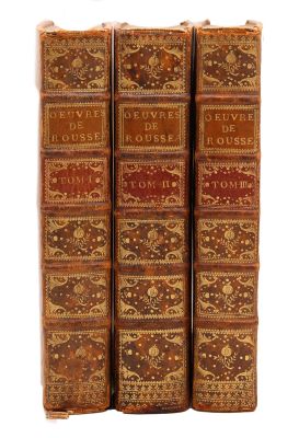 trois livres sont empilés sur une surface blanche