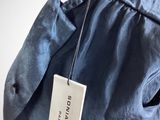 the back of a blue jacket with a tag hanging from it