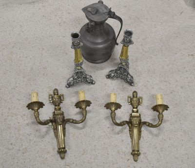 trois bougies et un vase posés côte à côte sur le sol
