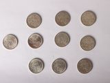 six types de pièces différents disposés en cercle sur une surface blanche