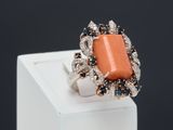 an image of a ring with an orange stone surrounded by blue and white diamonds