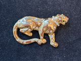 a close up of a brooch of a monkey on a black surface