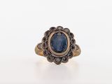 a close up of a ring with a blue stone in it