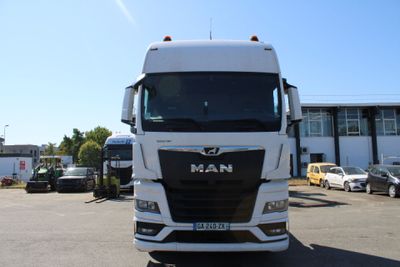 un camion blanc garé sur un parking à côté d'un immeuble