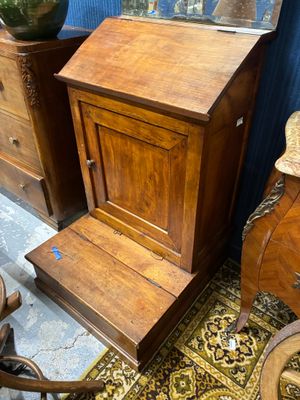 une petite armoire en bois et une chaise dans une pièce