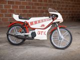a white and red motorcycle parked in front of a brick wall