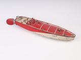 un petit bateau rouge posé sur une surface blanche