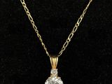 a yellow gold necklace with a diamond pendant on a chain