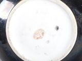 a close up of a black and white vase on a table