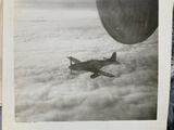 an old photo of a small plane flying above the clouds