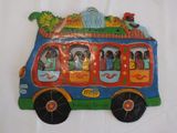 un petit bus avec des personnages assis dessus, posé sur une surface blanche