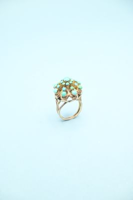 a close up of a gold ring with turquoise stones on it