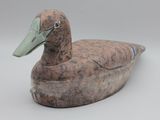 un petit canard en bois posé sur une table