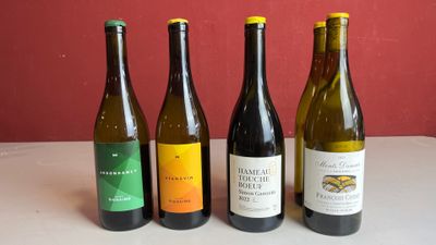 quatre bouteilles de vin sont alignées sur une table