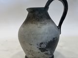 a black and white vase sitting on a white surface
