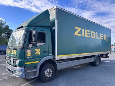 un camion vert garé sur un parking