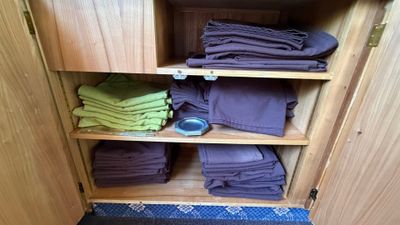 many folded towels on a shelf in a cabinet