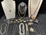 many necklaces and bracelets on display on a table
