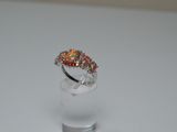 sterling silver ring with multi colored stones on top of a clear glass