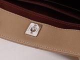 the inside of a tan and brown purse with a metal clasp