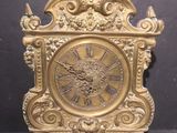 a gold clock with a face on the front of it